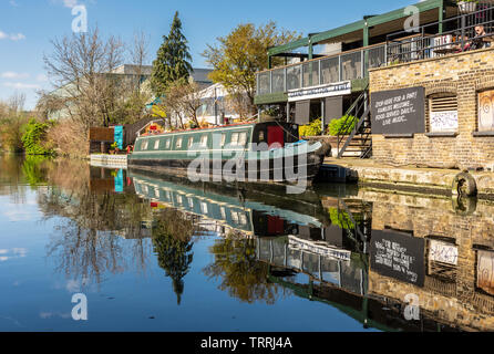 London, England, UK - March 24, 2019: A traditional narrowboat is moored on the Grand Union Canal beside Grand Junction Arms pub in North Acton. Stock Photo