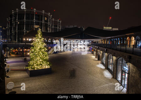 London, England, UK - December 14, 2018: People walk past Christmas decorations at the Coal Drops shopping centre in London's King's Cross regeneratio