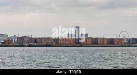 Liverpool, England, UK - November 4, 2015: Liverpool's gothic cathedral towers over the city skyline and warehouses of the Albert Dock as seen from th