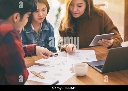 Three businessman using laptop and tablet pc while working and discussing business together in a meeting Stock Photo