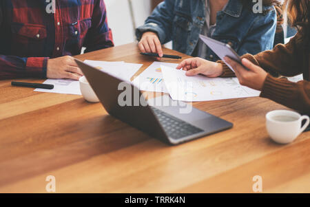 Three businessman using laptop and tablet pc while working and discussing business together in a meeting Stock Photo