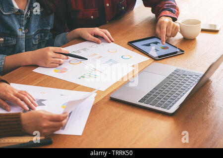 Three businessman using laptop and tablet pc while working and discussing business together in a meeting Stock Photo