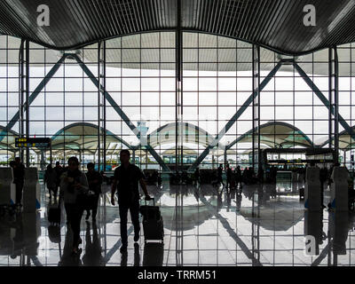 BAIYUN, GUANGZHOU, CHINA - 10 MAR 2019 – Silhouette view of travellers entering the departure hall of Baiyun Airport, one of the busiest airports in C Stock Photo