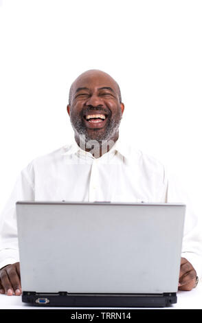 Portrait of cheerful African American software expert laughing while sitting front of a laptop computer.   Happy man working. Stock Photo
