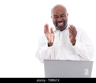Portrait of cheerful African American software expert laughing while sitting front of a laptop computer.   Happy man working. Stock Photo