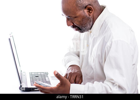 African American Male technician holding hard drive and loking at computer laptop Stock Photo