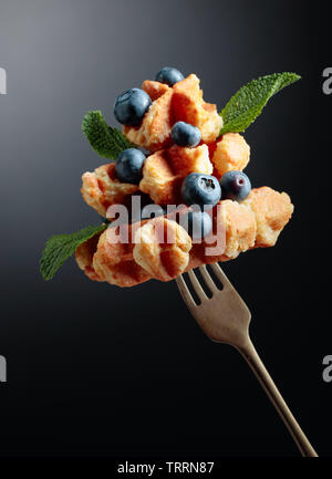 Homemade Belgian waffles with blueberry and mint on a dark background. Copy space. Stock Photo