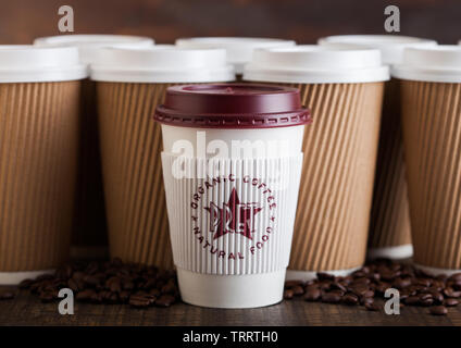 LONDON, UK - JUNE 05, 2019: Pret A Manger Coffee Paper Cup for take away with coffee beans on wooden background with brown coffee cups. Stock Photo