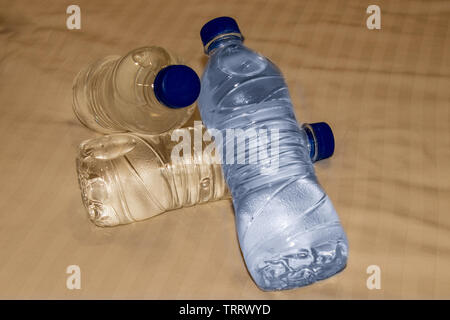 Plastic water bottles lying on bed. Stock Photo