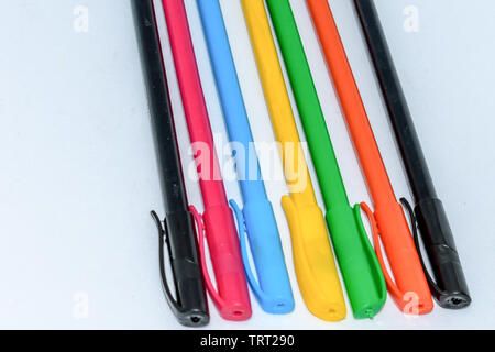 Close-up selection of Multi Colored Boll pint pens, close together in a row arrangement in white background, flat lay. Horizontal geometric art design Stock Photo