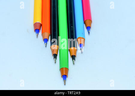 Close-up of a selection of Multi Colored boll point pens, stick together arranged in a row like bar graph on white background, flat lay. Selective foc Stock Photo