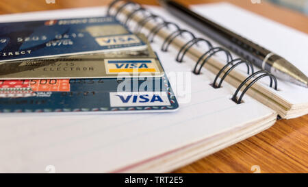 Goa India, 1 May 2019 - Close shot of Pile of VISA brand credit card, a pen and blank application form paper filling document on table. Shopping onlin Stock Photo