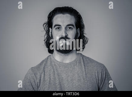 Close up headshot of young Hipster man with natural and neutral face with beard and long hair. Isolated on neutral background. In People, fashion, lif Stock Photo