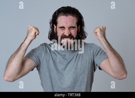 Portrait of young happy and excited hipster man winning the lottery celebrating goal or having great success with proud face. In People success and Fa Stock Photo