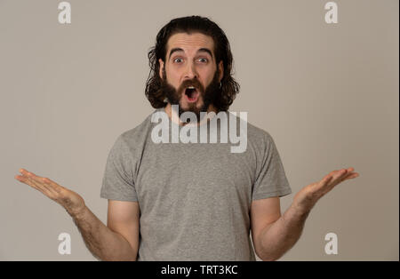 Portrait of funny attractive hipster man with happy and surprised face looking excited at something shocking good and unexpected. Human emotions and e Stock Photo