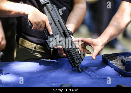 Details with the hands of a man holding a 9 mm automatic rifle Stock Photo