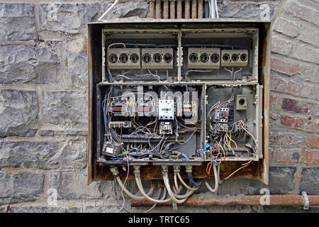Chaotic cables in a fuse box in an abandoned building Stock Photo