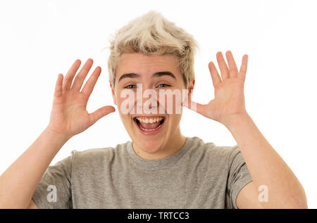 Close up portrait of handsome young blonde teenager boy making funny faces looking at the camera having fun. Transgender boy having fun In People humo Stock Photo