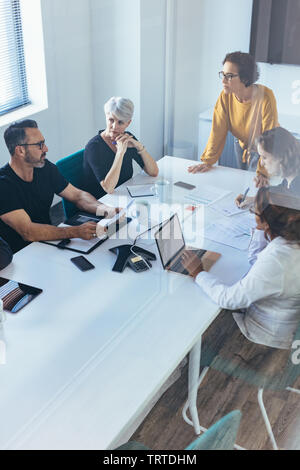Team of professional having a meeting in boardroom. business team having a brainstorming meeting in modern office. Stock Photo