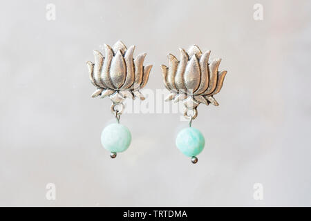 Mineral stone amazonite beads lotus shape earrings on neutral background Stock Photo