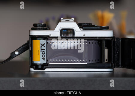 A single lens reflex camera with its back open as its loaded with a new roll of Kodak Tri Ex 400TX professional black and white film. Stock Photo