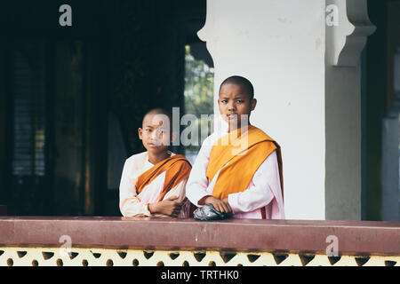 Yangon, Myanmar - March 2019: Buddhist female novice monks stand at the porch in Shwedagon pagoda temple complex. Stock Photo