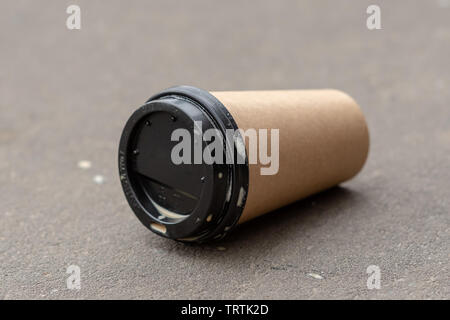 lying paper Cup of coffee on the ground. The theme of garbage in the city. Stock Photo