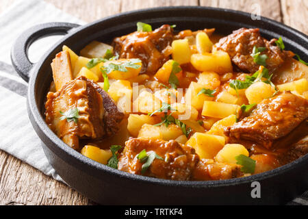 Homemade stew of short beef ribs with potatoes in a spicy sauce closeup in a pot on the table. horizontal Stock Photo