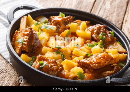 Slow cooked short beef ribs with potatoes in a spicy sauce close-up in a pot on the table. horizontal Stock Photo