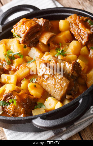 Slowly stewed short beef ribs with potatoes and gravy close-up in a pot on the table. vertical Stock Photo