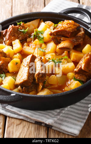 Beef ribs stewed with potatoes and gravy close-up in a pot on the table. vertical Stock Photo