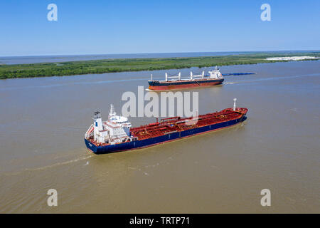 Empire, Louisiana - Ships on the Mississippi River below New Orleans. The Liberian oil/chemical tanker Tintomara (foreground) sails towards the Gulf o Stock Photo
