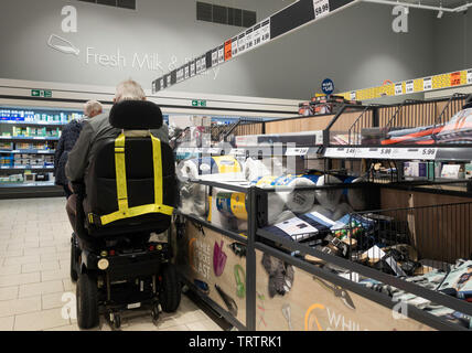 Elderlyperson in mobility scooter shopping in Lidl supermarket. UK Stock Photo