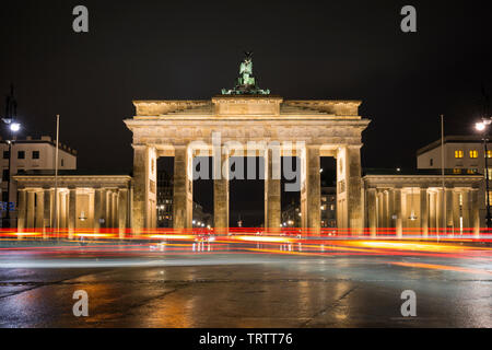 Traffic's light trails in front of the famous and illuminated Brandenburg Gate (Brandenburger Tor) in Berlin, Germany, at night. Stock Photo