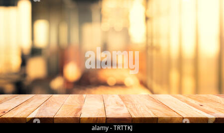 Wood table top (Bar) with blur light bokeh in dark night cafe,restaurant background Stock Photo