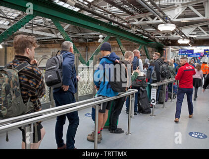 Edinburgh, UK. 12th June, 2019. Long queues of very frustrated passengers awaiting alternative transport by bus due to damage to the overhead wires between Carlisle and Lockerbie stations, all lines are blocked, warns 'services will be delayed as a result. Passengers require to check for updates to your journeys/services' Stock Photo