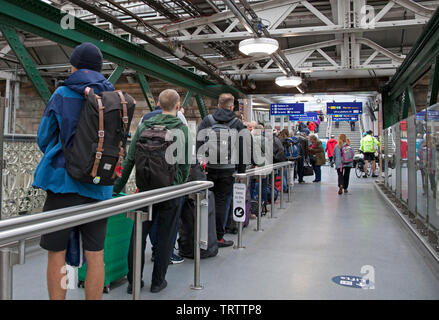 Edinburgh, UK. 12th June, 2019. Long queues of very frustrated passengers awaiting alternative transport by bus due to damage to the overhead wires between Carlisle and Lockerbie stations, all lines are blocked, Virgin Twitter feed warns 'services will be delayed as a result. Passengers require to check for updates to your journeys/services' Stock Photo