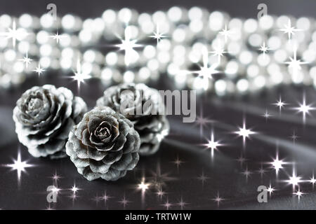 Three silver cones and bead chain on grey cloth background Stock Photo