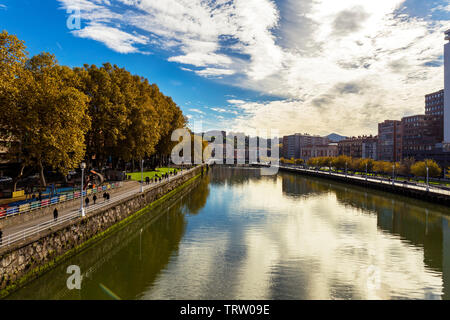 Bilbao, Spain - november 04, 2018: view of Nervion river in Bilbao city with people wlaking  along the  bank of  river. Spain , on november 04, 2018 i Stock Photo