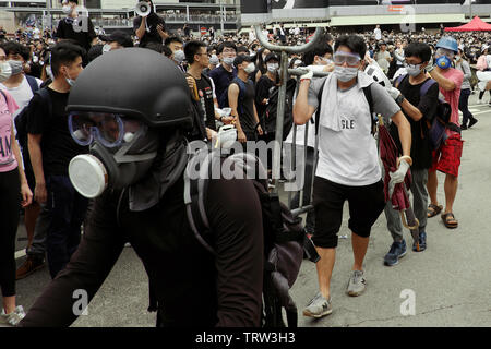 Hong Kong, China. 12th June, 2019. Unidentified individuals move metal barricades during protests against extradition law in the legislative council area Hong Kong Credit: Thomas Bertson/Alamy Live News Stock Photo