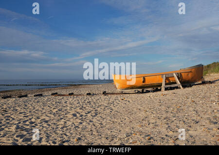 yellow boat moored on deserted beach Stock Photo