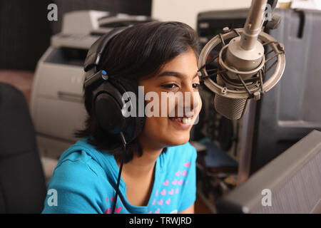 Girl disc jockey speaking into a microphone Stock Photo