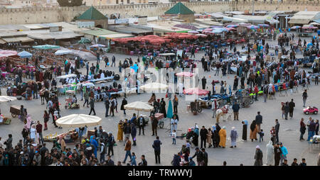 Wide angle view of El Hedim Square with restaurants, bars, countless market stalls and crowded with people and hawkers in the evening. Meknes, Morocco Stock Photo