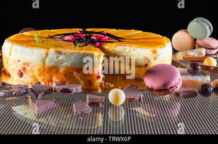 Close-up of a set of delicious cake, macaroons and chocolate candies above a glass table Stock Photo