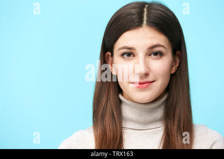 head and shoulder portrait of a young caucasian woman isolated on blue background Stock Photo