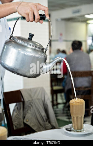 A waiter pours hot milk into coffee at the iconic Gran Café de La Parroquia  along the Malecon in Veracruz City, Mexico. The cafe is known for their  long pours of hot