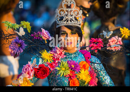 NEW YORK CITY - JUNE 25, 2017: A transgender drag performer wearing flowers with her beauty queen tiara passes on a float in the gay pride parade. Stock Photo