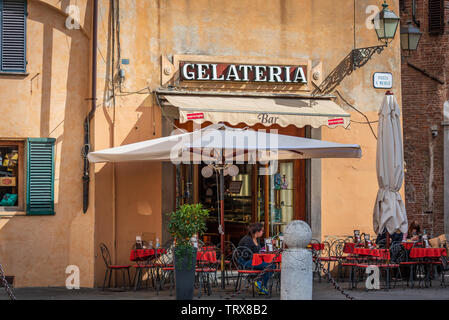 Sidewalk tables from a bar / gelateria / ice cream place in Piazza San Michele in Lucca, Tuscany, Italy Stock Photo