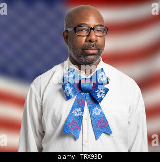 Portrait of a patriotic african american man with glasses and Fourth of July bow tie against American flag backdrop. Stock Photo