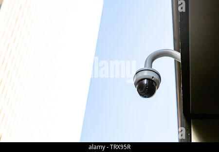 CCTV Security system. Surveillance Camera on the roof, white and blue color background, low angle closeup view Stock Photo